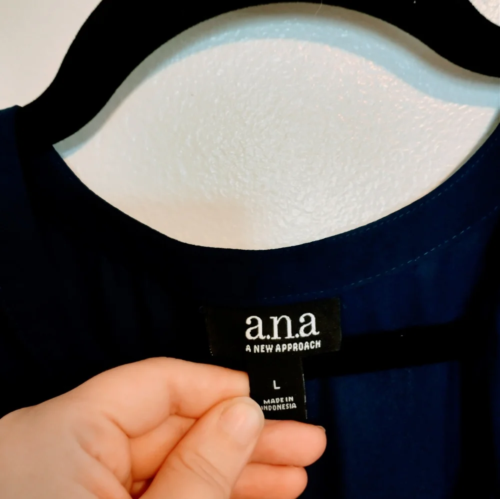 Ana blue long sleeve tunic with peplum detail near the hem and drawstrings at th
